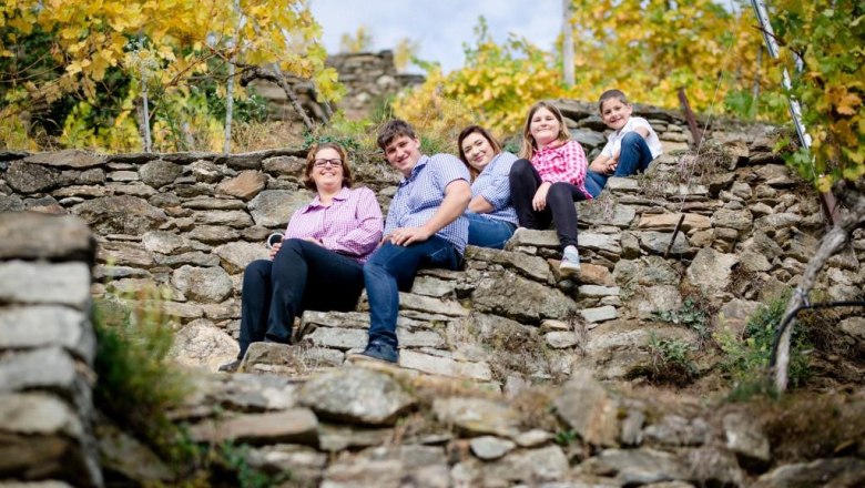 Kropf Winery, © Alexander Pfeffel Family sitting on stone steps in the vineyard.