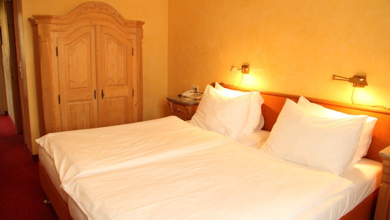 Room, © Oldtimer Hotel room with double bed, wooden furniture and warm light.