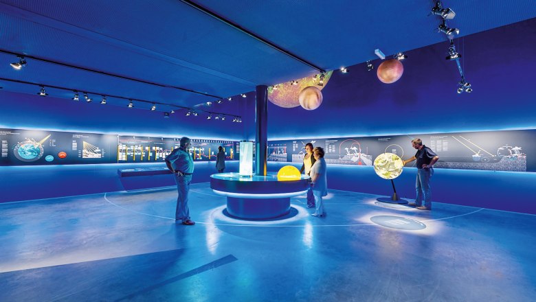 SONNENWELT Großschönau, © Sonnenwelt/Klaus Pichler Interior view of the SONNENWELT Großschönau exhibition with blue lighting and interactive exhibits.