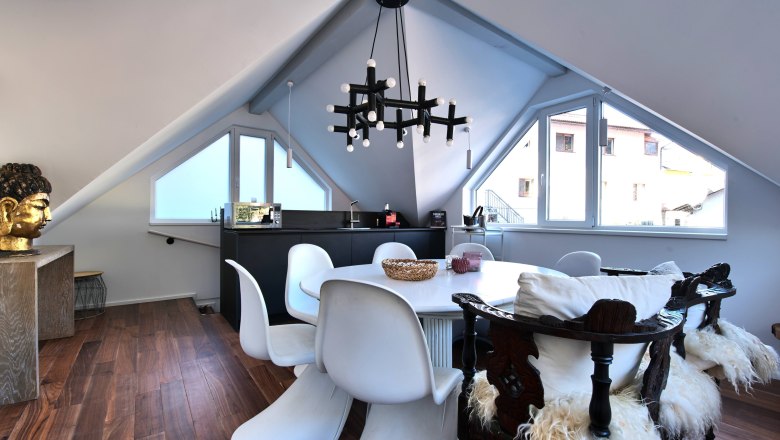 Dining areaTop 4, © Daniela Sinadinoska Modern dining area in a loft with white chairs, wooden floor and a large window.