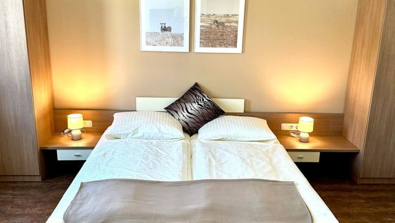 Family room, © Johnys Jungle Modern bedroom with double bed, two bedside tables and wall pictures.