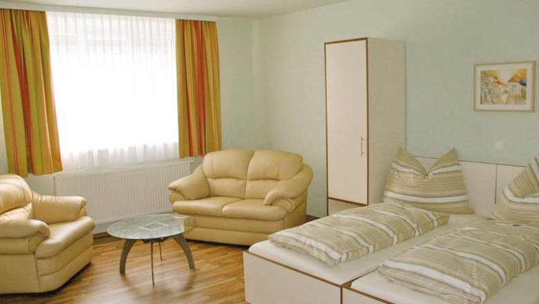 sunny double room, © 2013. All Rights Reserved Bright room with two beds, sofas, a table and a wardrobe.