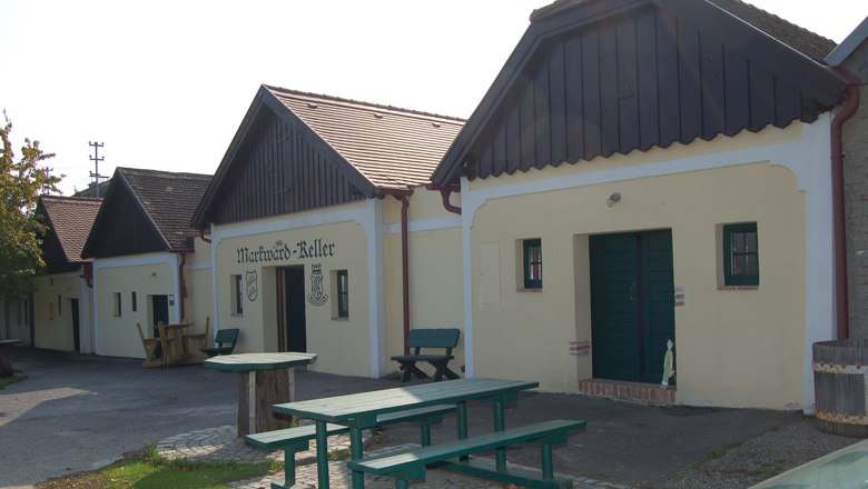 St. Markward's cellar, © Regina Baumgartner Traditional wine cellars with wooden benches and outdoor tables.