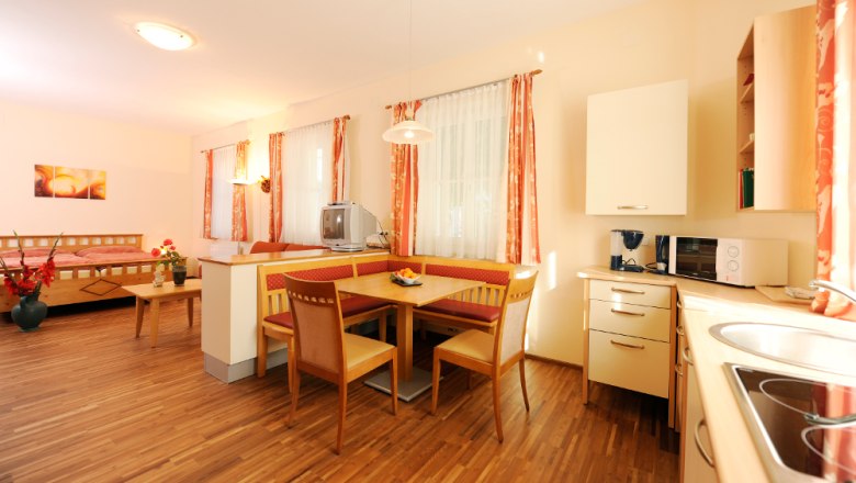 Room, © Steve Haider Bright room with wooden floor, dining table, kitchen and bed.