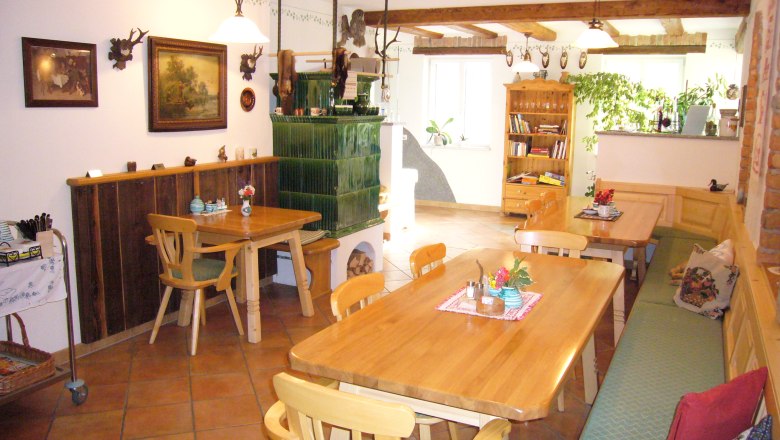 Mayrhof Haag, © zVg Cozy guest room with wooden furniture and tiled stove.