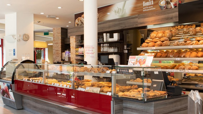 Comfortable coffee breaks., © Koll GmbH Interior view of a bakery with bread and pastries on display.