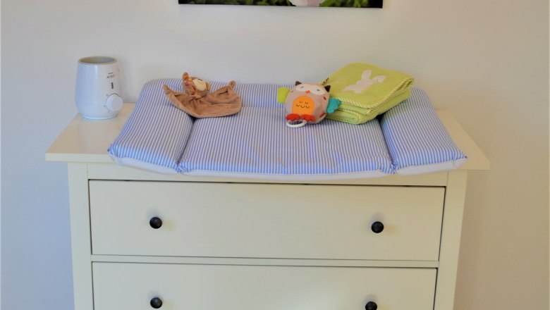 Cozy Höblinghof, © Gluschitz-Goebel Changing table with blue pad, toys and decorations on the wall.