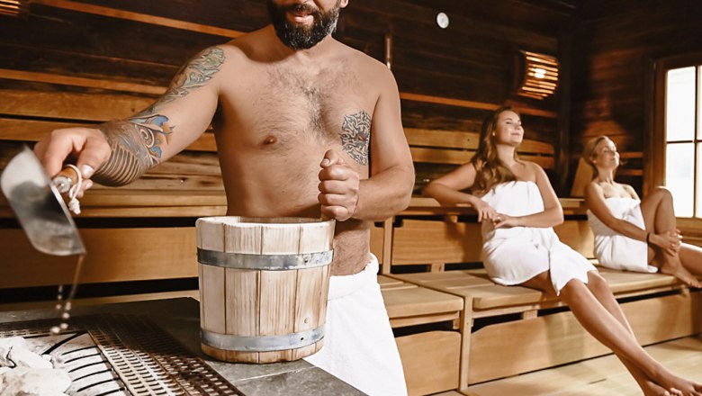 Würflacher Wellness World, © A. Drazdansky @ TheVerve - Agentur Man pouring water into sauna, two women sitting relaxed.