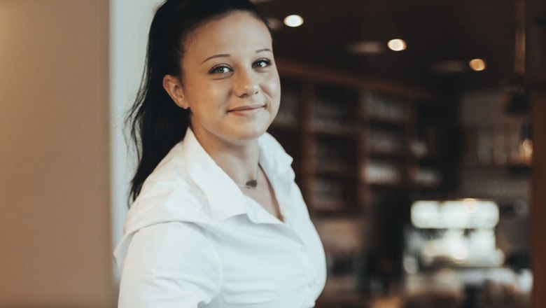 There for the guests: Sopie Eder, © Niederösterreich Werbung/David Schreiber Woman in white shirt smiles into the camera, background blurred.