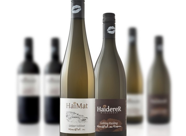 haider_6, © Matthias Haiderer Two wine bottles in the foreground, blurred bottles in the background.