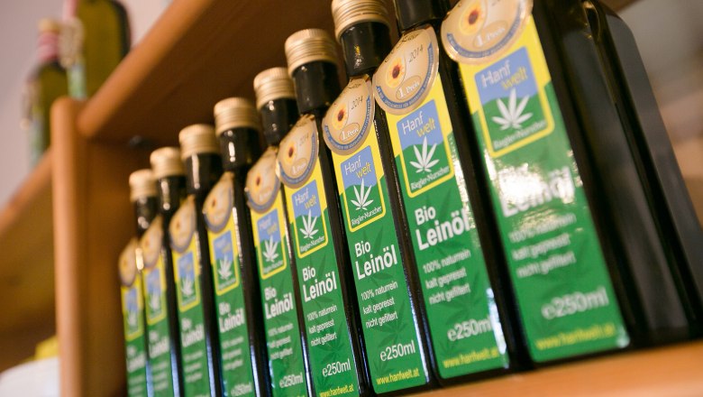 Organic hemp Nurscher, © Doris Schwarz König Row of organic linseed oil bottles on a wooden shelf.