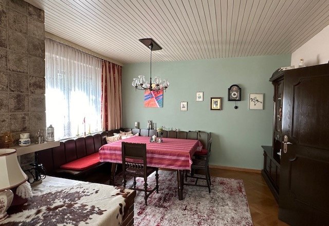 Living room, © Heidi Peer Cozy living room with dining table, corner bench, carpet and wall clock.