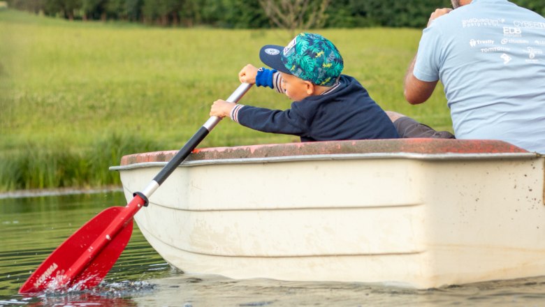 Boating on the pond, © Familie Moser A child and an adult are rowing in a small boat on a pond.