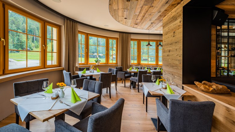 Restaurant, © Christian Kremsl Elegant restaurant with wooden elements, laid tables and large windows overlooking the greenery.