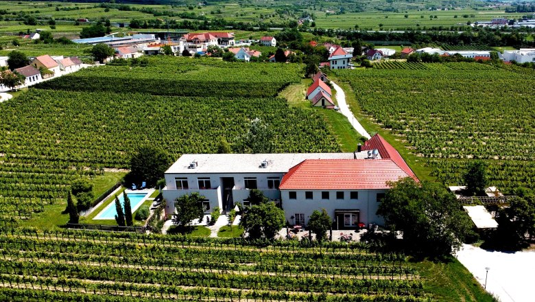 View from above of the inn and the surrounding vineyards, © Werner Wachsmann Verlag Aerial view of an inn surrounded by vineyards.