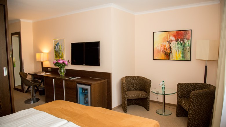 Double room superior, © Hotel Admiral am Kurpark Hotel room with double bed, desk, TV and two armchairs.