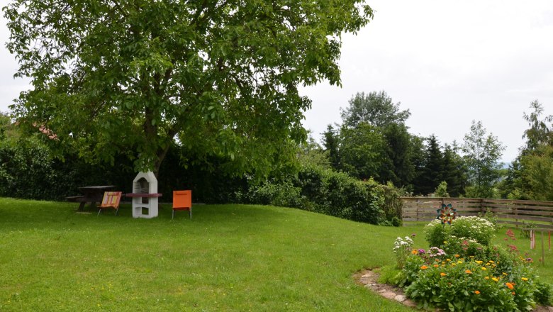 garden_17, © Karl Temper A green garden with a tree, garden furniture and a flower bed.