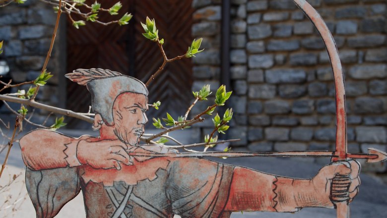 Robin Hood, © Scherz/Kremser Cardboard figure of Robin Hood with bow and arrow in front of a stone wall.