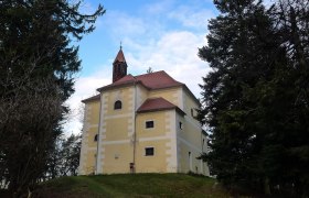 Rosalia Chapel, © alpenlandmagazin.at Chapel with yellow façade on a hill surrounded by trees.