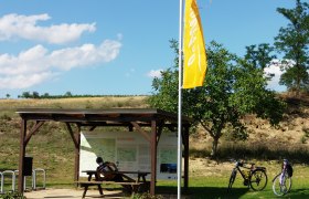 Cycling rest at the Zeißlkreuz, © Weinsraße Weinviertel Cyclists' rest area with wooden table, two bicycles and information board in the Weinviertel.