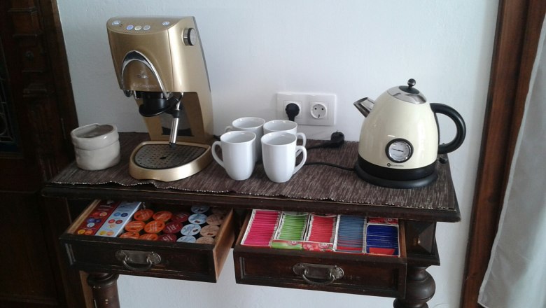 Breakfast room, © Ullram Coffee machine and kettle on a table with cups and tea bags.