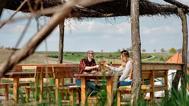 Enjoyment on the sun terrace, © Michael Reidinger Two people clink glasses of wine on an outdoor terrace.