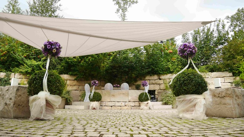Wedding in the love garden, DIE GARTEN TULLN, © DIE GARTEN TULLN Outdoor wedding decoration with purple flowers and white chairs.