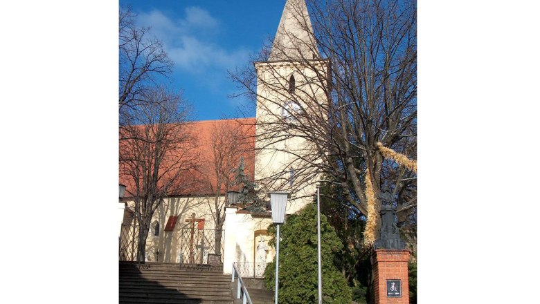 Parish church, © Gemeinde Altlichtenwarth Parish church with tower and red roof tiles, surrounded by trees and steps in the foreground.