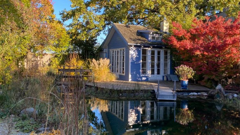 Rainbowsend fall mood, © U.Weber Small blue house by the pond, surrounded by colorful autumn trees.