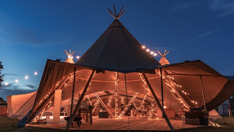 Tipi example for an event, © Szilagyi An illuminated tipi tent at night, decorated with fairy lights, prepared for an event.