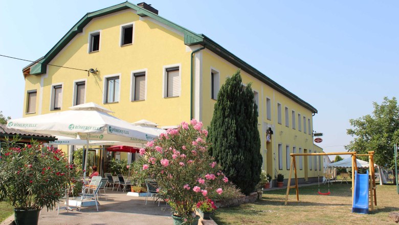 Gasthof Strasser, © Gasthof Strasser Yellow building with terrace and playground in the foreground.