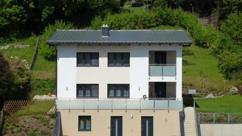 House "Weinengel", © Harrauer Two-storey modern house with balcony, surrounded by green countryside.