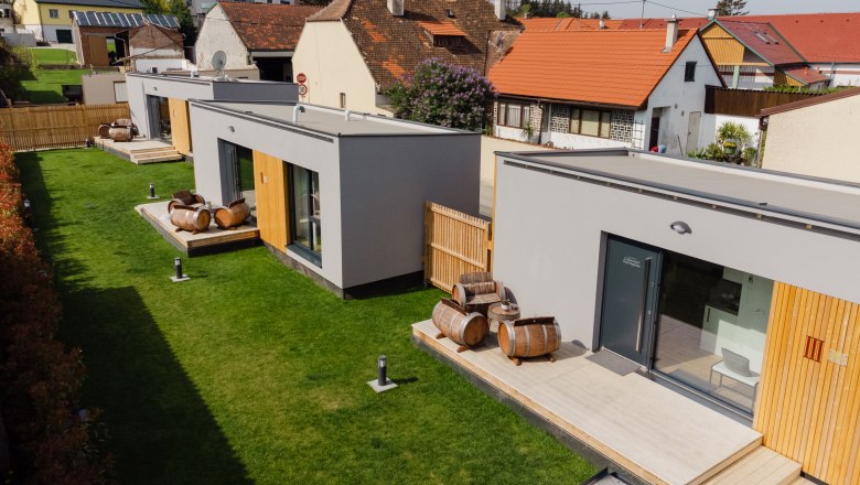 Ipsmiller Apartments, © Michael Reidinger Modern apartments with wooden barrel decoration on a green meadow.