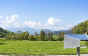 Jagasitz Muggendorf, © Wiener Alpen - Zwickl Green meadow with mountains in the background and a blurred object in the foreground.