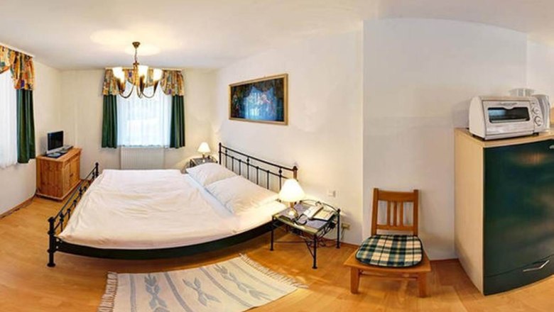 Apartment 30m², © Haus Lenz Small bedroom with double bed, bedside tables, TV, microwave and chair.