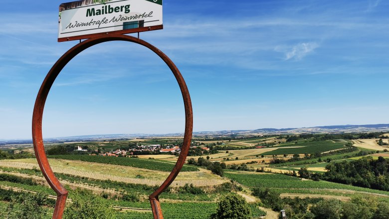 A look through the keyhole, © Weinstraße Weinviertel Landscape with vineyards and a sign with the inscription 'Mailberg Wein Road Weinviertel'.