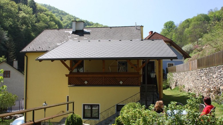 House view, © Bergkirchner Yellow house with balcony, surrounded by green landscape and stone wall.