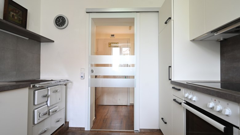 Kitchen, © Christine Kuppelwieser Modern kitchen with stove, cupboards and glass door.