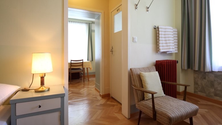 Spend the night in the Looshaus., © Christian Redtenbacher Interior view of a room in the Looshaus with armchair, bedside lamp and table in the background.