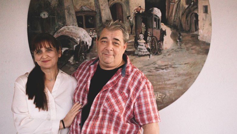 Hosts Alexandra Turek & Christian Vlasaty, © Niederösterreich Werbung/Mara Hohla A man and a woman are standing in front of a painting on the wall.