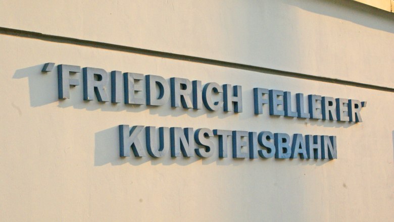 Artificial ice rink, © Wiener Alpen/Katrin Zeleny Lettering 'Friedrich Fellerer Kunsteisbahn' on a wall.