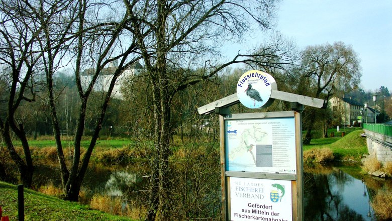 Market town of Karlstein, © Marktgemeinde Karlstein A river trail sign on a riverbank with bare trees in the background.