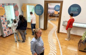 Traismauer Castle, © WeinArtZone People in a museum look at interactive exhibitions with text panels and exhibits.