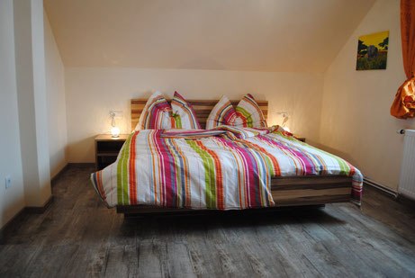 Room example Pension Wieselmayer, © Familie Wieselmayer Double bed with colorful striped bed linen
