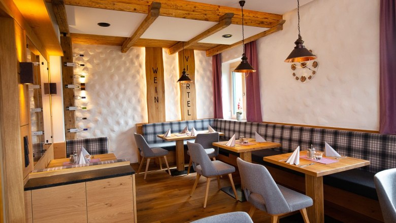 Restaurant, © Hotel Stich Cozy restaurant with wooden furniture, laid tables and purple curtains.
