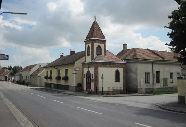 Lanzendorf, © Pop Werner Street in Lanzendorf with church and residential buildings.