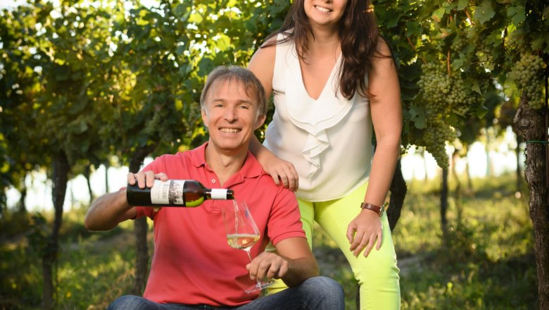 Organic viticulture Christian Mrozowski, © www.digitalimage.at Two people in a vineyard, one sits on a crate and pours wine, the other stands next to it and smiles.