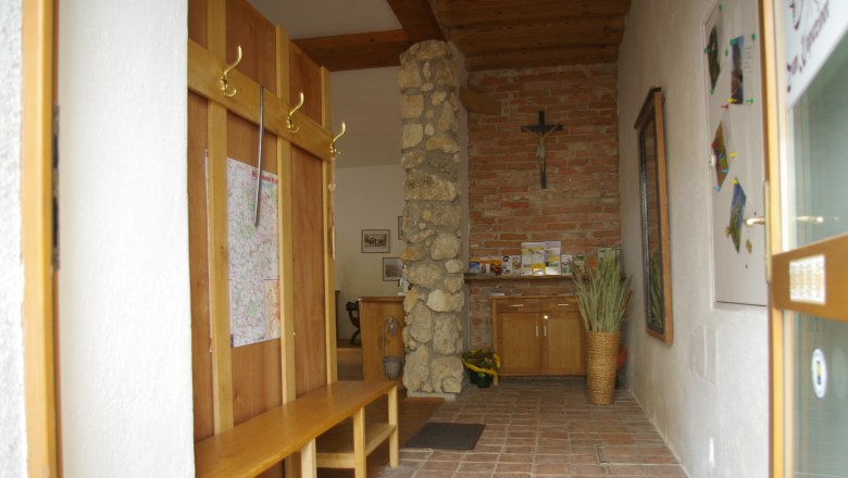 Entrance area, © Fam. Zangl Entrance area with wooden benches, stone wall and cross.