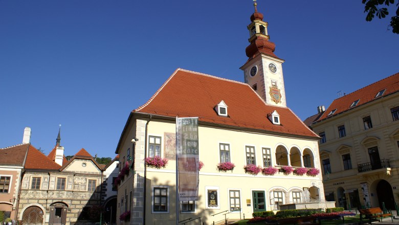 Mödling, © Mödling Historic building with tower and clock in Mödling, surrounded by blue sky.