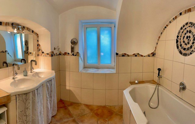 Bathroom, © Julia Grünschachner A bathroom with double washbasin, bathtub and tiled floor.